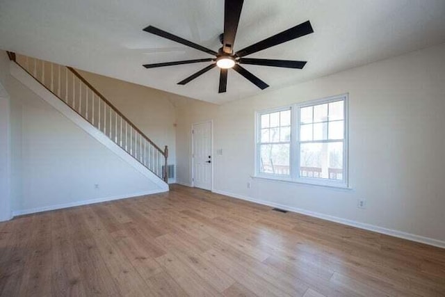 interior space featuring baseboards, visible vents, ceiling fan, stairway, and wood finished floors