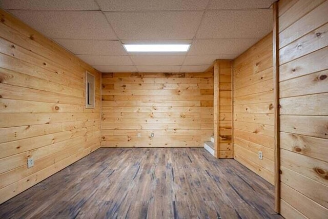 spare room featuring a sauna, wooden walls, a drop ceiling, and wood finished floors