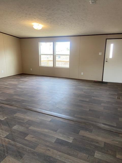 spare room featuring a textured ceiling and wood finished floors