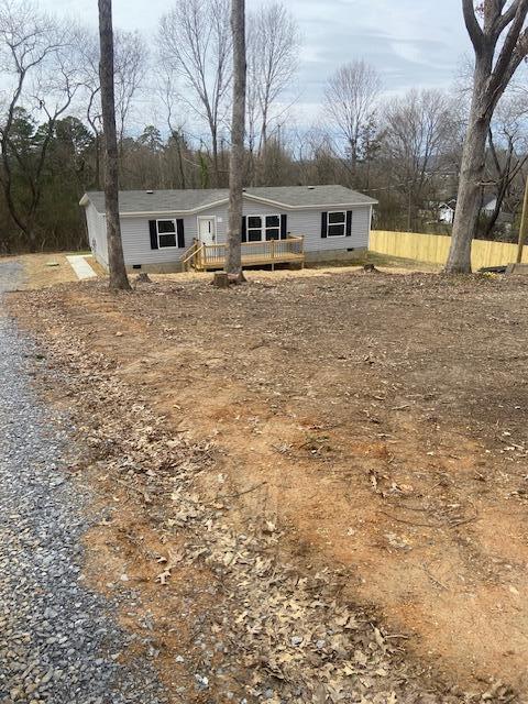 manufactured / mobile home featuring crawl space and gravel driveway