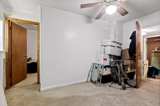 interior space with ceiling fan, light colored carpet, and a textured ceiling