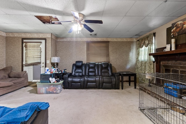 carpeted cinema room with a drop ceiling and ceiling fan