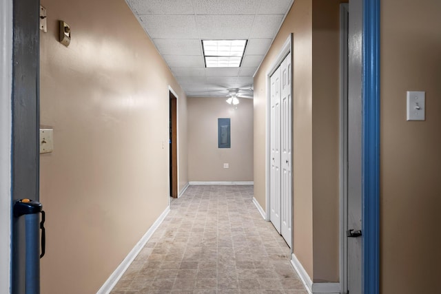 hallway featuring electric panel and a drop ceiling