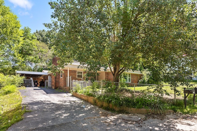 view of property hidden behind natural elements featuring a carport