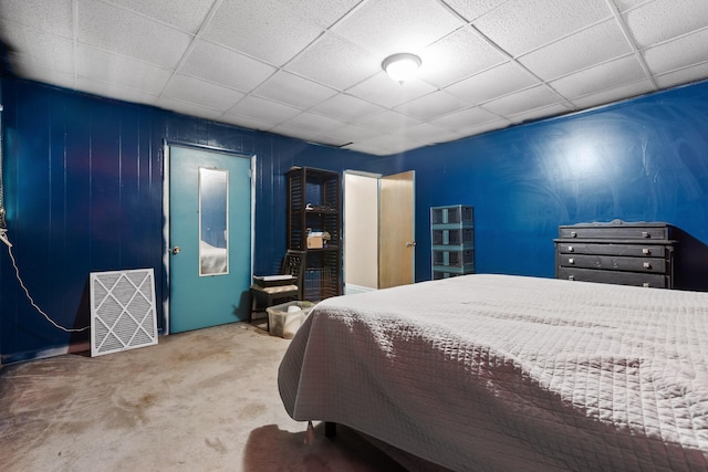 carpeted bedroom featuring a drop ceiling