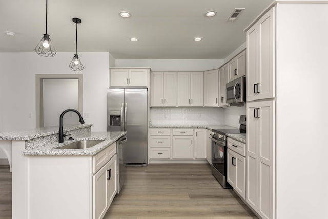 11942 Old Dayton Pike, Soddy-Daisy, TN 37379 - kitchen with appliances with stainless steel finishes, a sink, light wood finished floors, an island with sink, and visible vents