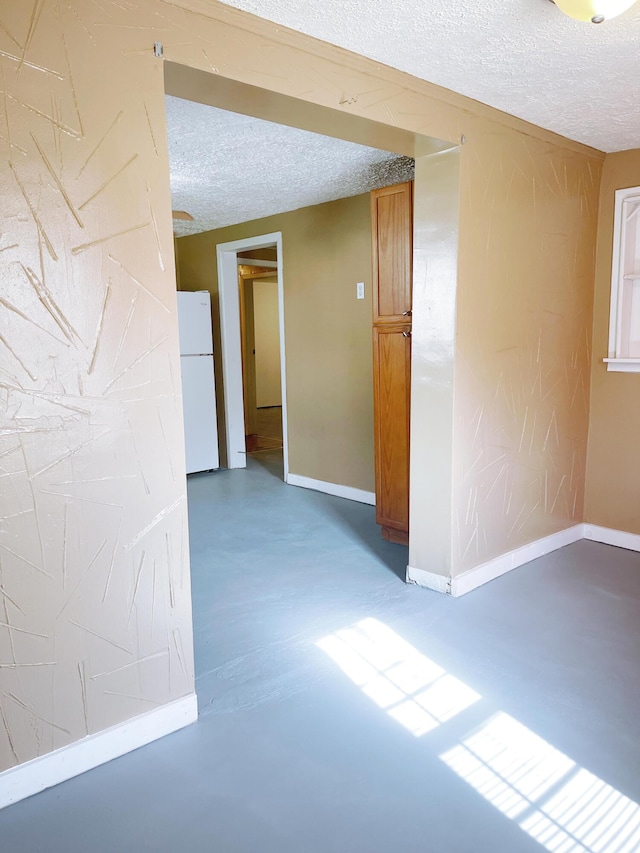 spare room featuring a textured ceiling and concrete floors