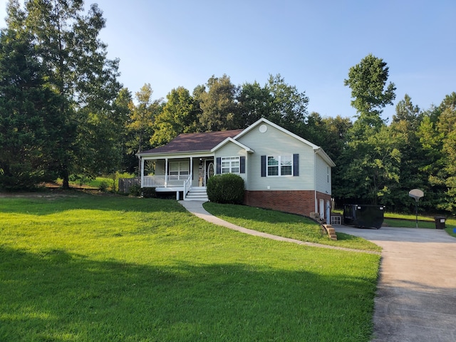 view of front of home with a porch, concrete driveway, an attached garage, and a front lawn