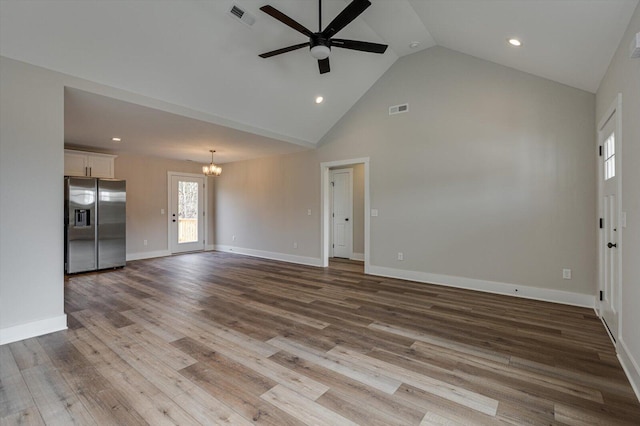 unfurnished living room featuring ceiling fan with notable chandelier, high vaulted ceiling, and light hardwood / wood-style flooring