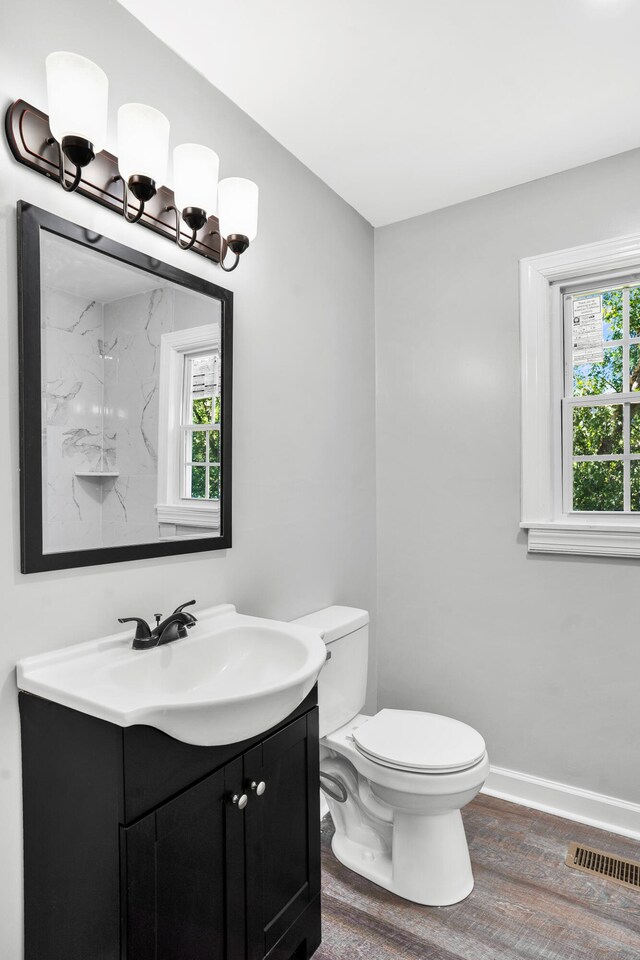 bathroom featuring hardwood / wood-style floors, plenty of natural light, toilet, and vanity