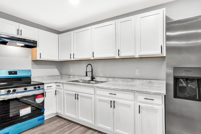 kitchen with light hardwood / wood-style floors, white cabinetry, sink, and appliances with stainless steel finishes