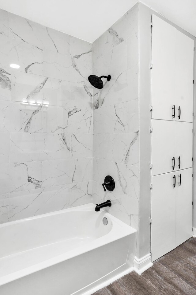 bathroom featuring wood-type flooring and tiled shower / bath combo