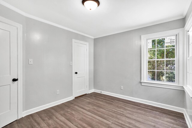 empty room with crown molding and dark wood-type flooring