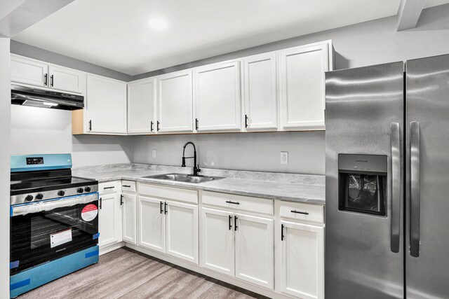 kitchen featuring light stone countertops, sink, stainless steel appliances, light hardwood / wood-style floors, and white cabinets