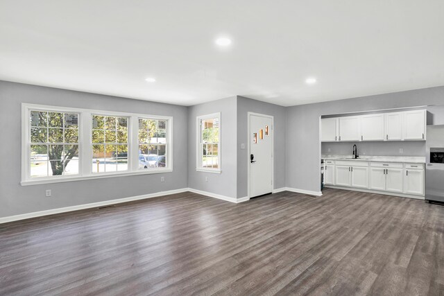 unfurnished living room with dark wood-type flooring and sink