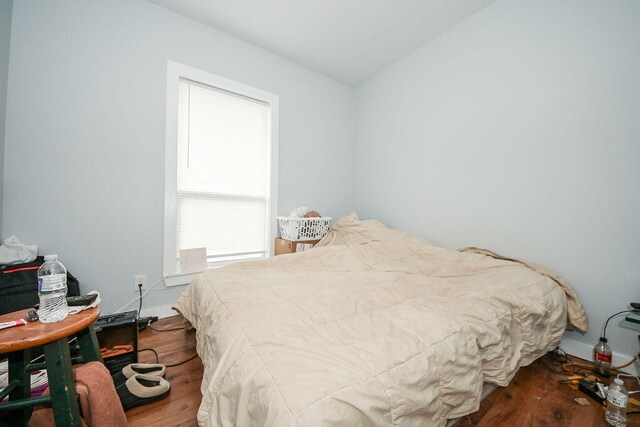 bedroom featuring vaulted ceiling and hardwood / wood-style flooring