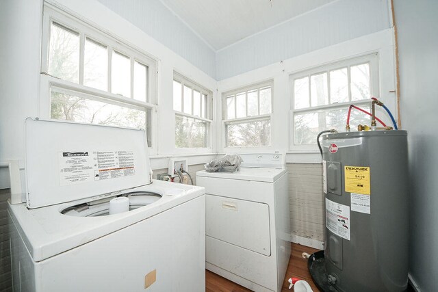 washroom featuring washing machine and dryer, tile walls, dark wood-type flooring, and water heater