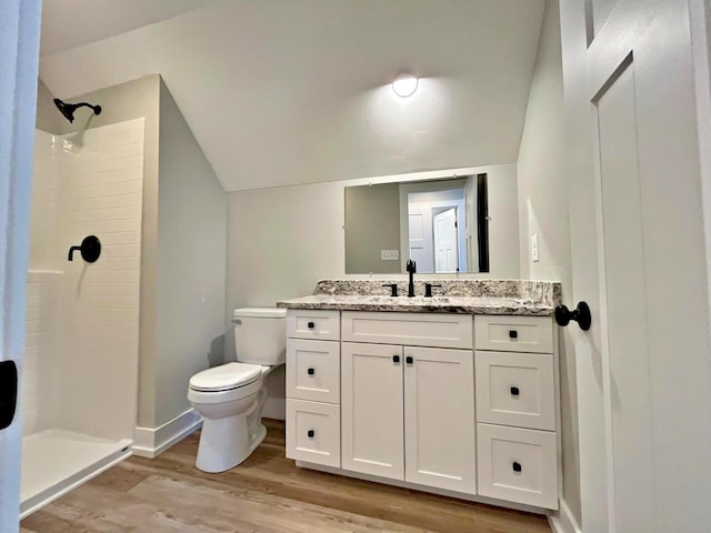 bathroom featuring hardwood / wood-style flooring, toilet, walk in shower, and lofted ceiling