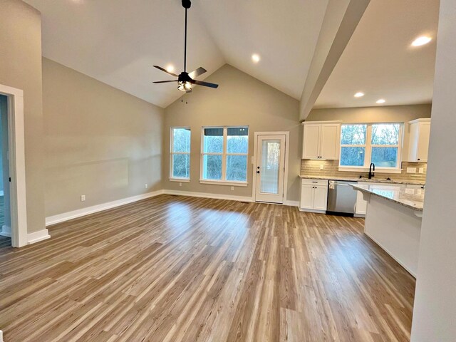 unfurnished living room with ceiling fan, light hardwood / wood-style floors, and a healthy amount of sunlight