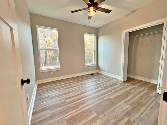 unfurnished bedroom featuring ceiling fan, a closet, and light hardwood / wood-style flooring