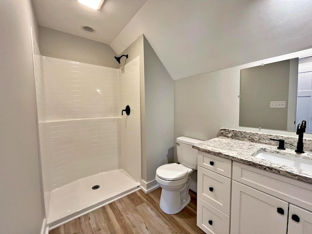 bathroom with hardwood / wood-style floors, vanity, toilet, and a shower