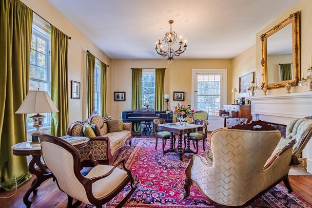 sitting room featuring wood-type flooring and an inviting chandelier