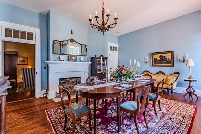 dining space with dark hardwood / wood-style flooring and an inviting chandelier