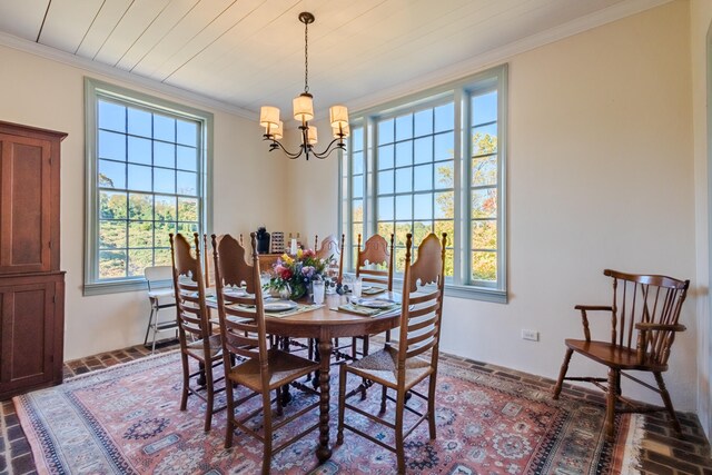 dining room featuring plenty of natural light, ornamental molding, and an inviting chandelier