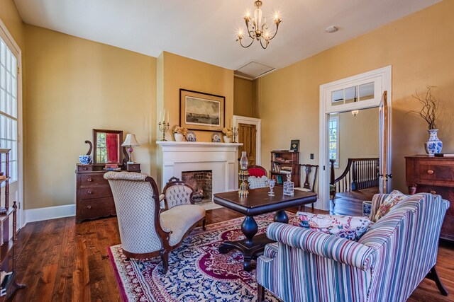 living room featuring a notable chandelier, dark hardwood / wood-style floors, and a healthy amount of sunlight