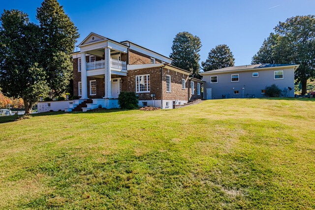 view of front of house featuring a front yard and a balcony