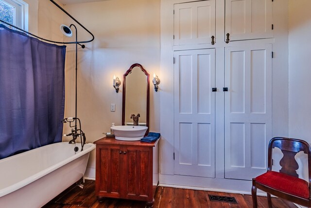 bathroom featuring hardwood / wood-style floors, vanity, and shower / tub combo