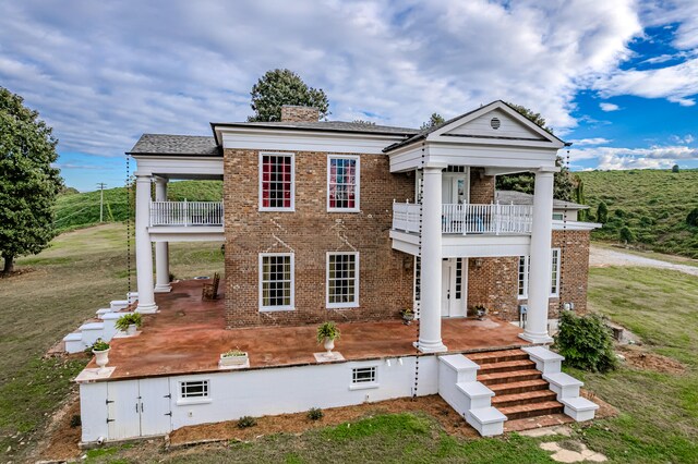 view of front of property with a balcony and a front yard