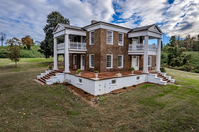 exterior space with a balcony and a front yard