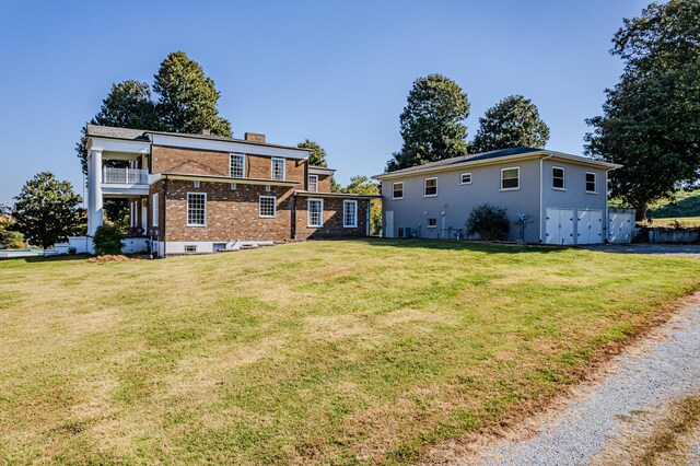 rear view of property with a yard and a balcony