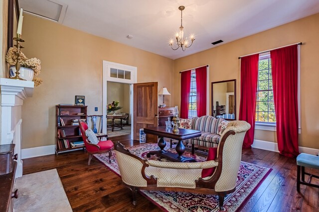 living room featuring dark hardwood / wood-style flooring and an inviting chandelier