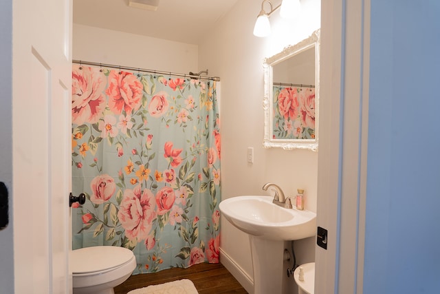 bathroom featuring sink, toilet, a shower with shower curtain, and hardwood / wood-style flooring