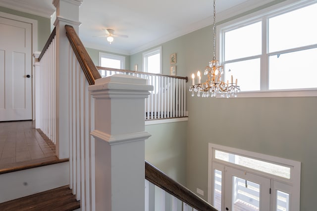 staircase with wood-type flooring, crown molding, and a wealth of natural light