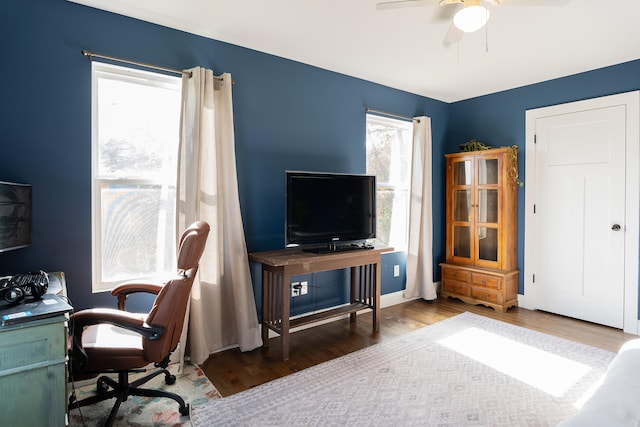 office featuring ceiling fan, dark wood-type flooring, and a healthy amount of sunlight