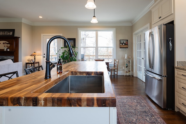 kitchen with stainless steel refrigerator, pendant lighting, wooden counters, and dark hardwood / wood-style floors