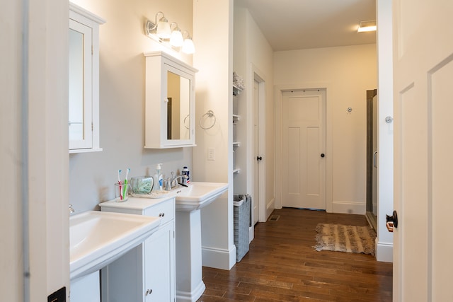 bathroom with dual sinks and hardwood / wood-style flooring