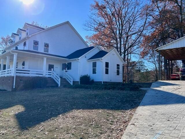 view of side of property featuring covered porch