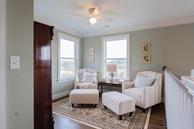 living area with dark hardwood / wood-style flooring, crown molding, ceiling fan, and a healthy amount of sunlight