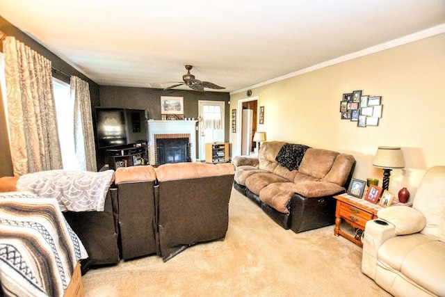 carpeted living room featuring ceiling fan, crown molding, and a brick fireplace