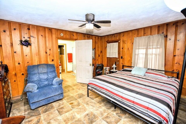 bedroom featuring ceiling fan and wood walls