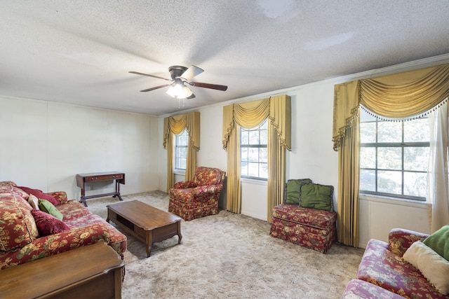 carpeted living room featuring a textured ceiling, ceiling fan, and crown molding