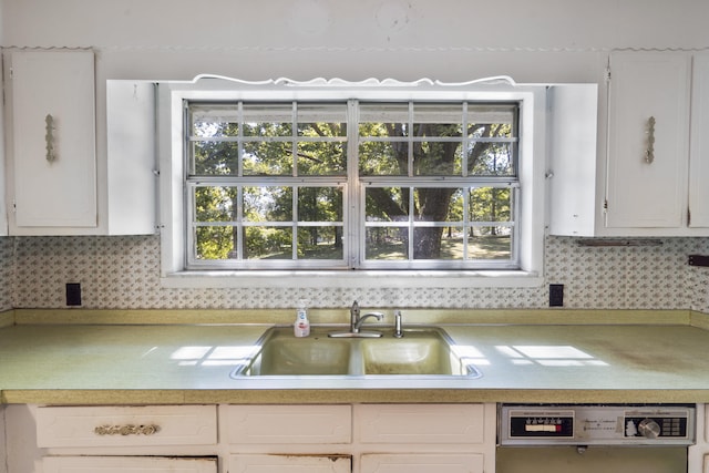 kitchen with backsplash, sink, white cabinets, and stainless steel dishwasher