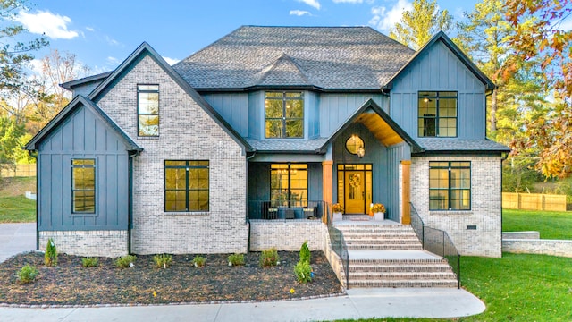 modern farmhouse style home featuring a porch and a front lawn