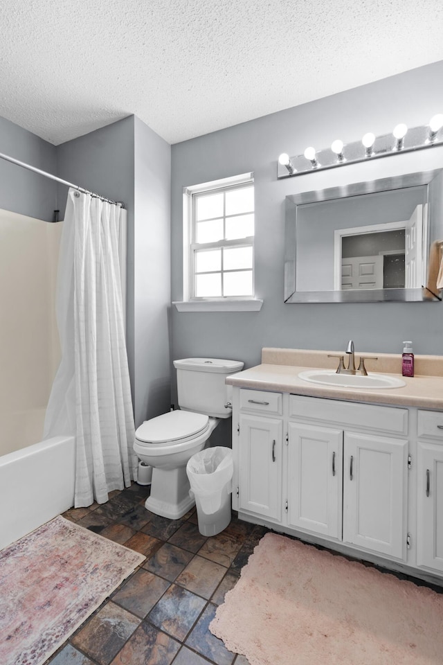 full bath with toilet, a textured ceiling, vanity, and shower / tub combo