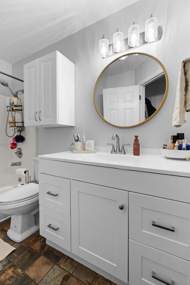 full bathroom with toilet, stone finish floor, shower / tub combination, a textured ceiling, and vanity