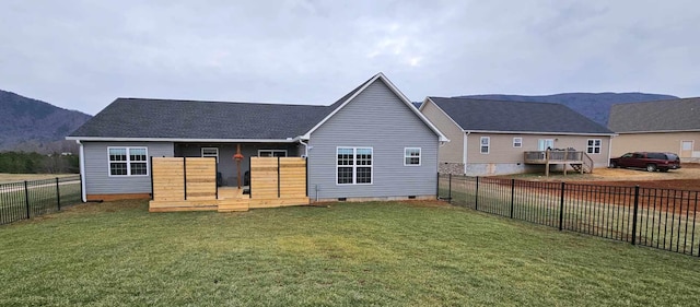 rear view of house featuring a mountain view and a yard